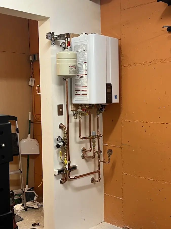 Plumbing technician inspecting water heater connections in Whitesboro